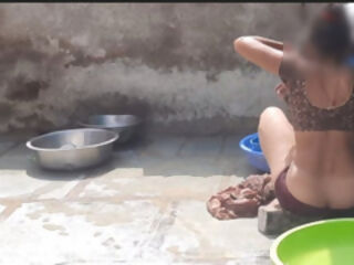 In the country&amp;#039;s bathroom of the village, the elder sister-in-law&amp;#039;s stepsister is soaking her saree in water and bathi